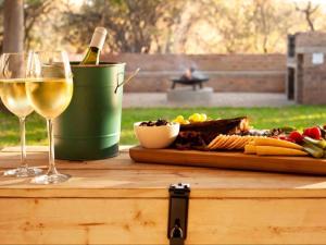 a table with a bottle of wine and wine glasses at Nzenga Lodge in Hoedspruit