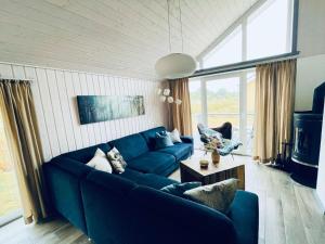 een woonkamer met een blauwe bank en een tafel bij Ferienhaus im Ferienpark Mirow in Granzow