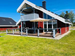 een huis met een terras met een tafel en een paraplu bij Ferienhaus im Ferienpark Mirow in Granzow