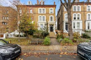 a house with two cars parked in front of it at Luxury modern 1 bed between Hampstead and Camden in London