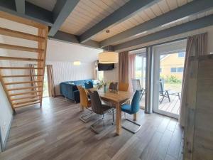 een eetkamer met een tafel, stoelen en een bank bij exklusives skandinavisches Ferienhaus in Granzow