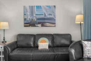 a leather couch in a living room with a sign on it at Oceanfront Family Suite - Full Kitchen - Beach Access - Pool & Hot Tub in Lincoln City +28 photos