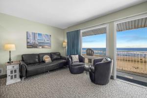 a living room with a couch and chairs and a balcony at Oceanfront Family Suite - Full Kitchen - Beach Access - Pool & Hot Tub in Lincoln City