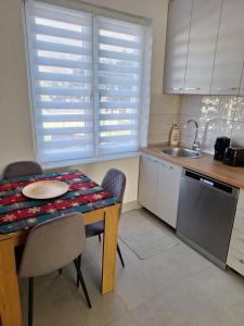 a kitchen with a table with chairs and a sink at Apartman Centar in Drvar +8 photos