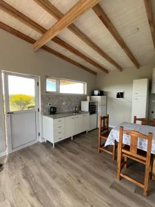 a kitchen and dining room with a table and chairs at Cabaña Flor Tandil in Tandil