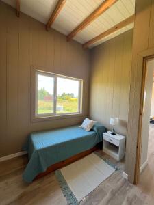 a small bedroom with a bed and a window at Cabaña Flor Tandil in Tandil