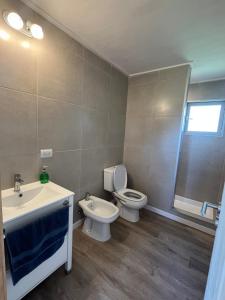 a bathroom with a toilet and a sink at Cabaña Flor Tandil in Tandil +12 photos