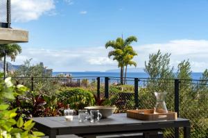 a table on a balcony with a view of the ocean at Luxury Apartment at Savoy Monumentalis by An Island Apart in Funchal +29 photos