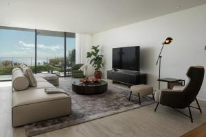 a living room with a couch and a tv at Luxury Apartment at Savoy Monumentalis by An Island Apart in Funchal