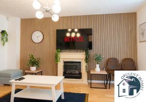 un soggiorno con camino e TV di Detached 4 bed - Modern Contractor Pad - Reading a Caversham