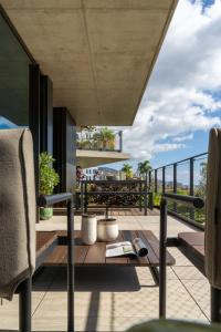 a room with a table and chairs on a balcony at Luxury Apartment at Savoy Monumentalis by An Island Apart in Funchal