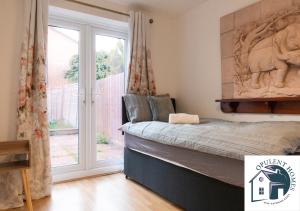 una camera da letto con un letto e una grande finestra di Detached 4 bed - Modern Contractor Pad - Reading a Caversham