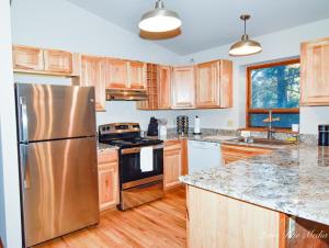 une cuisine avec des armoires en bois et un réfrigérateur en acier inoxydable dans l'établissement Durango Colorado Four Bedroom Two Bathroom Home, à Durango