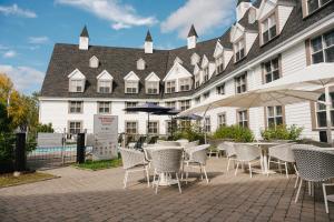 a group of tables and chairs in front of a building at Gîte du Mont-Albert - Sepaq in La Martre