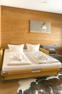 a bedroom with a bed with a deer painting on the wall at Apartmenthaus Der Johanneshof - tolle Lage nah am See in Schliersee