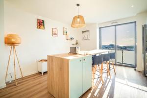 a kitchen with a counter and a counter top with a table at Duplex d Exception Vue sur le port de Quiberon in Quiberon