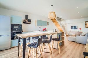 a kitchen and living room with a counter and stools at Duplex d Exception Vue sur le port de Quiberon in Quiberon