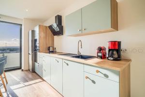 a kitchen with white cabinets and a counter top at Duplex d Exception Vue sur le port de Quiberon in Quiberon