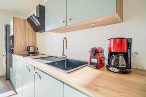 a kitchen with a sink and a appliance on a counter at Duplex d Exception Vue sur le port de Quiberon in Quiberon +28 photos