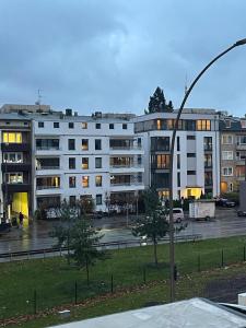 een groot wit appartementencomplex op een parkeerplaats bij Milano Apartment in Hamburg