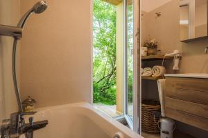 Un baño con bañera y ventana. en Luxus Ferienhaus für Familie und Hund, en Bad Aussee 82 fotos más