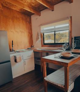 Una cocina con una mesa y una ventana. en Cabaña con vista al volcán, en Neltume