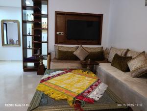 a living room with a couch and a tv at Océane palm in Casablanca