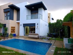 a house with a swimming pool in front of a house at Océane palm in Casablanca