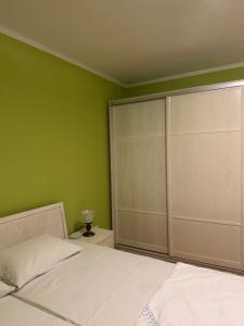 a bedroom with a white bed and green walls at KMB suite in Nikšić