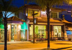 a building with tables and chairs outside at night at Pousada do Centro in Búzios