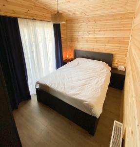 a bedroom with a bed in a wooden room at Tianeti Apple Cottages 