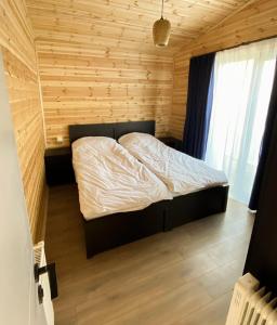 a bedroom with a bed in a wooden room at Tianeti Apple Cottages 