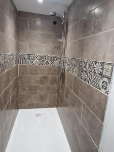 baño con ducha con azulejos en la pared en Logement neuf 6 personnes ancienne ferme, en Censeau