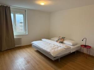 een witte slaapkamer met een bed en een raam bij Canaima in Luzern