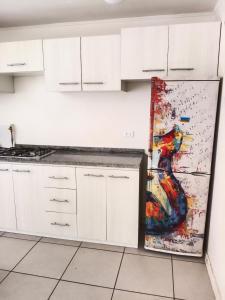 une cuisine avec une peinture murale représentant une guitare dans l'établissement Departamento hualpen, à Hualpen