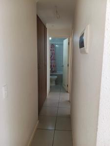 un couloir menant à une salle de bains avec toilettes et lavabo dans l'établissement Departamento hualpen, à Hualpen