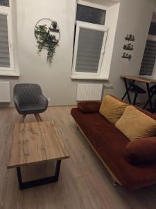 a living room with a couch and a table and windows at Aurelija in Daugavpils
