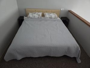 a bedroom with a bed with a white bedspread and pillows at Aurelija in Daugavpils