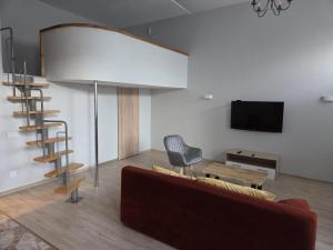 a living room with a couch and a chair and a television at Aurelija in Daugavpils