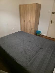 a bedroom with a bed and a wooden cabinet at Habitación zabalburu D&S in Bilbao