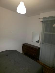 a bedroom with a bed and a dresser and a mirror at Habitación zabalburu D&S in Bilbao