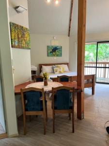 een eetkamer met een tafel en stoelen en een slaapkamer bij Fern Cottage in Mangonui
