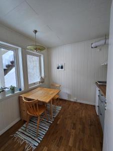 a dining room with a wooden table and two chairs at Downtown apartment in Svolvær in Svolvær