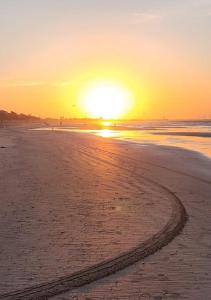 路易斯科雷亚Casa Atalaia的沙滩上的日落，沙滩上有一条小路