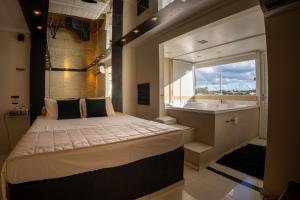 a bedroom with a bed and a tub and a sink at Hotel e Motel Paradiso - Passo Fundo-RS in Passo Fundo