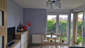 a living room with a table and chairs and a window at Osiedle Morskie in Pogórze