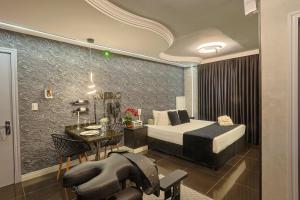 Hotel Motel Paradiso - Passo Fundo-RS في باسو فوندو: غرفة نوم بها سرير وطاولة وكرسي