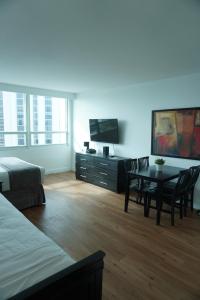une chambre avec un lit, une table et une télévision dans l'établissement Shine Suites Studio 11, à Miami Beach
