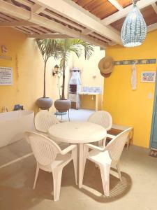 una sala da pranzo con tavolo, sedie e vasca di Pipa Magnólia Chalés a Pipa
