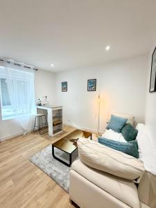 ein weißes Wohnzimmer mit einem Sofa und einem Schreibtisch in der Unterkunft Appartements meublés Brest centre in Brest